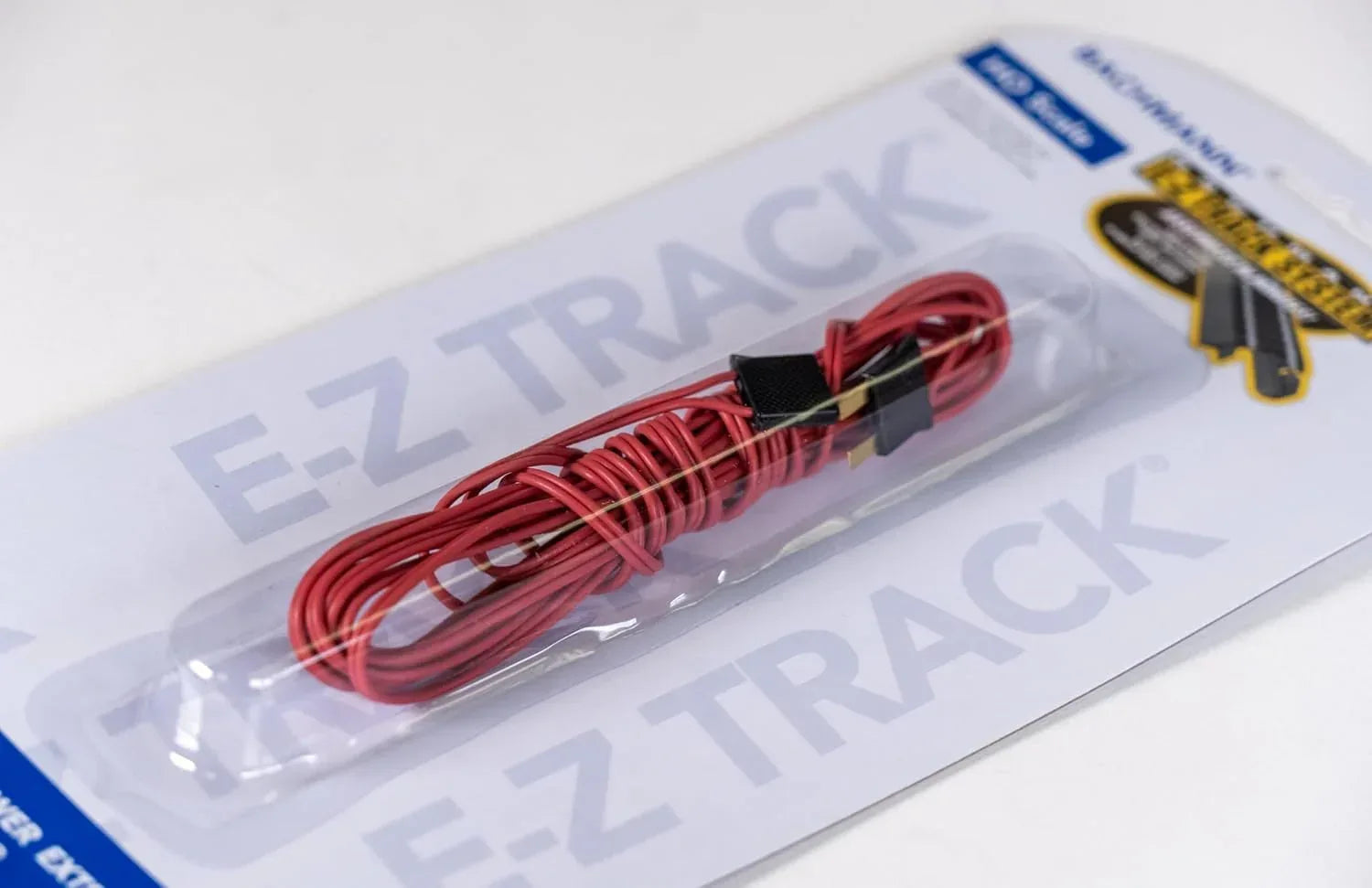 Red Bachmann Trains E-Z Track 10-foot power extension wire, ideal for model railway power connections, shown with cable and connectors.