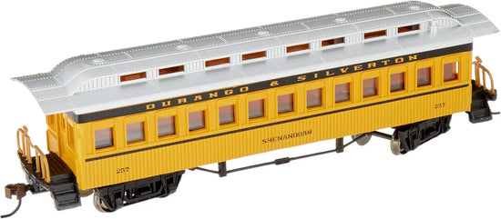 Bachmann yellow passenger car for model railroads, detailed prototype design, sits on tracks with windows and realistic features