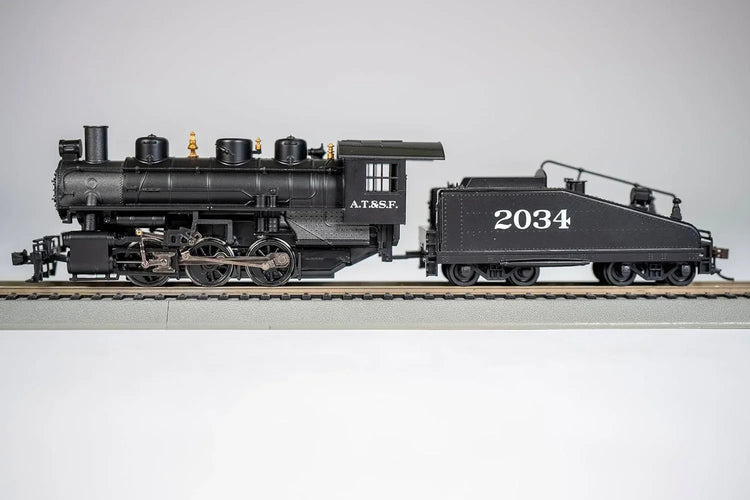 Bachmann HO scale ATSF USRA 0-6-0 locomotive with smoke and slope tender on model railway track.