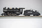 Bachmann HO scale ATSF USRA 0-6-0 locomotive with smoke and slope tender on model railway track.