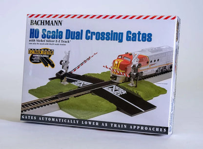 HO scale Bachmann Trains E-Z Track crossing gate, medium size, with rail tracks and safety barrier on model train layout.
