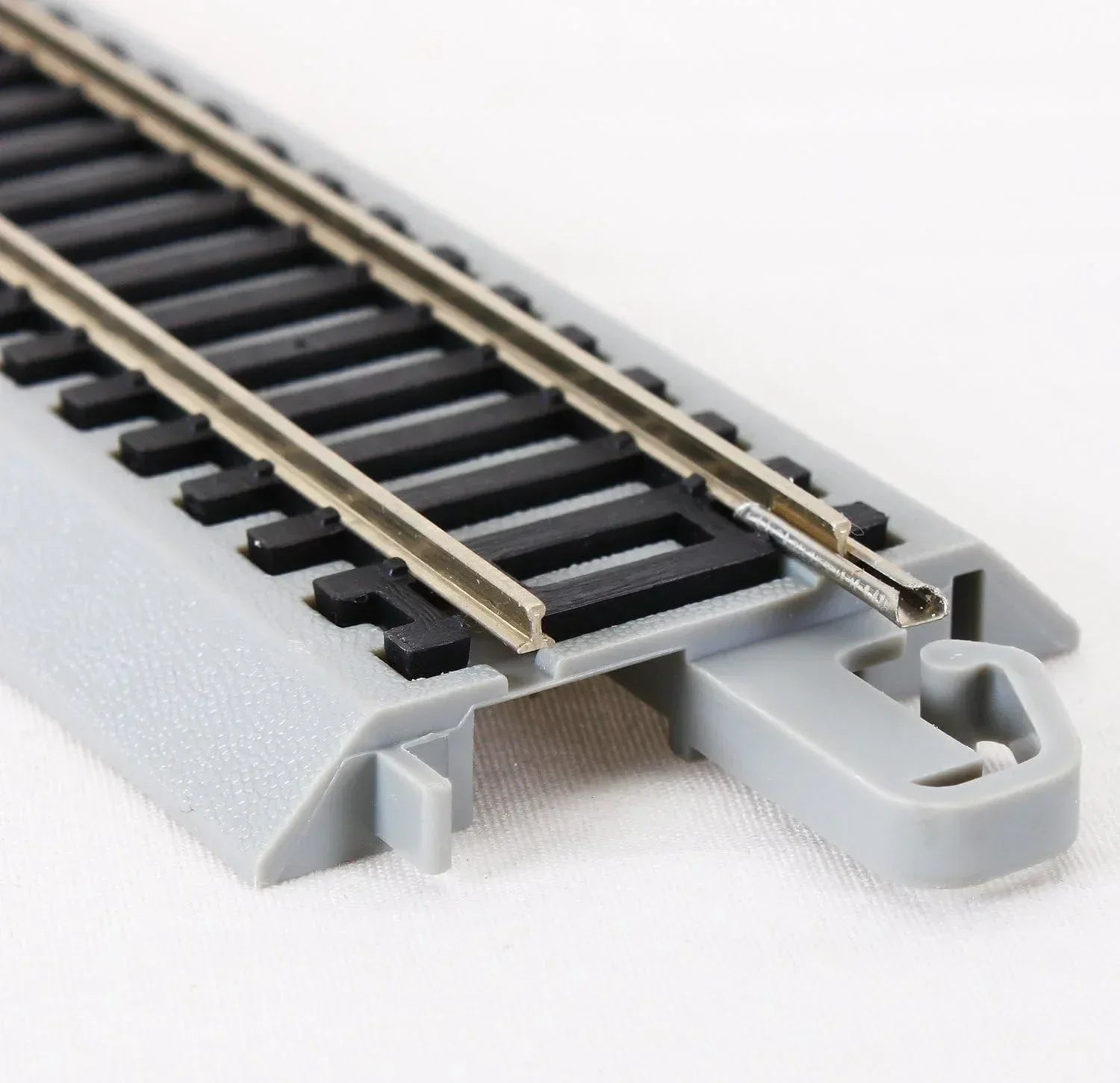 Four Bachmann Trains HO scale snap-fit E-Z Track 3-inch straight sections with nickel silver rails and gray roadbed.