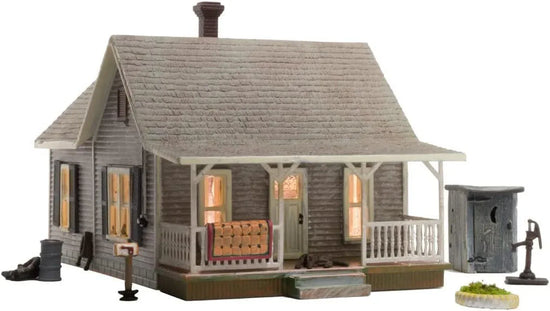 Woodland Scenics Old Homestead N Scale Model Kit showing a detailed miniature rural house with trees and fencing.