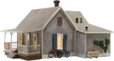 Woodland Scenics BR4933 Old Homestead N scale model kit showing a detailed miniature rural farmhouse with surrounding landscape.