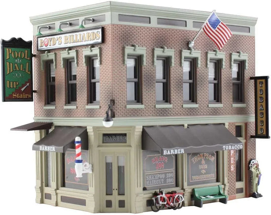 HO scale model kit of a corner emporium building by Woodland Scenics, featuring detailed miniature architecture and realistic textures.