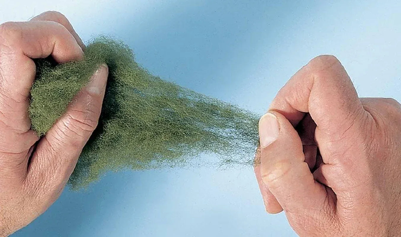 Woodland Scenics 16G green polyfiber material for model scenery, shown in a small pile with fiber strands.